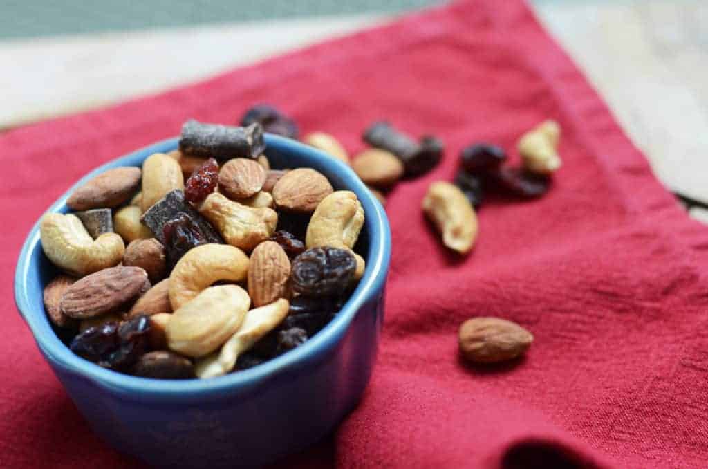 close up view of paleo trail mix in a blue bowl on top of a red napkin