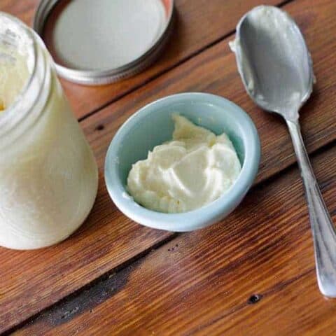 overhead view of an open jar of homemade mayonnaise with a bowl and spoon