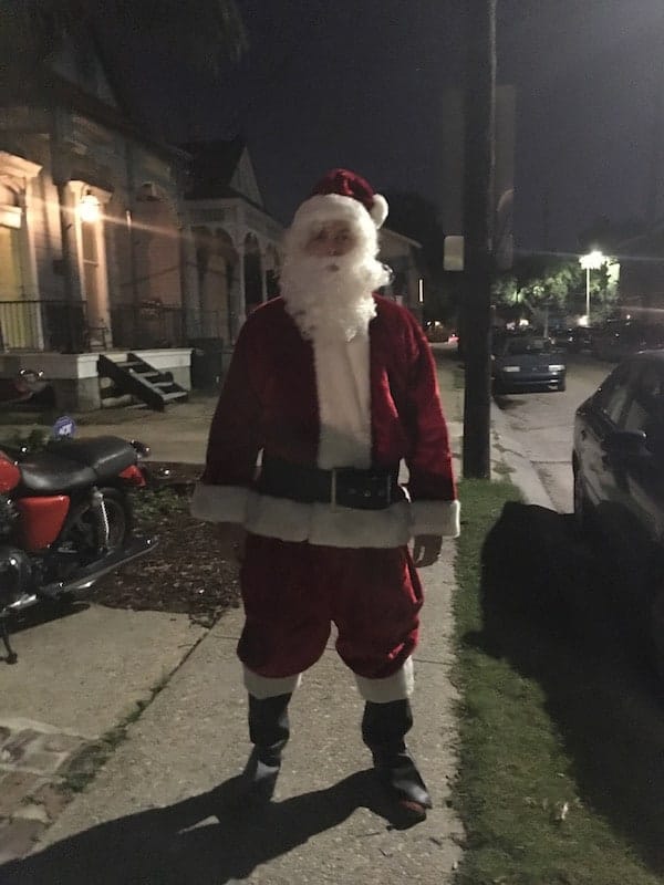 man in santa suit on sidewalk