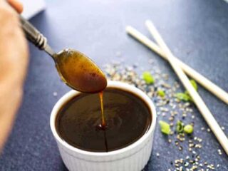 spoon with teriyaki sauce drizzling into a bowl of sauce