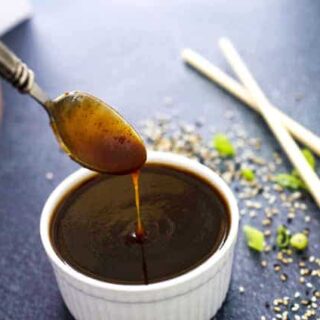 spoon with teriyaki sauce drizzling into a bowl of sauce