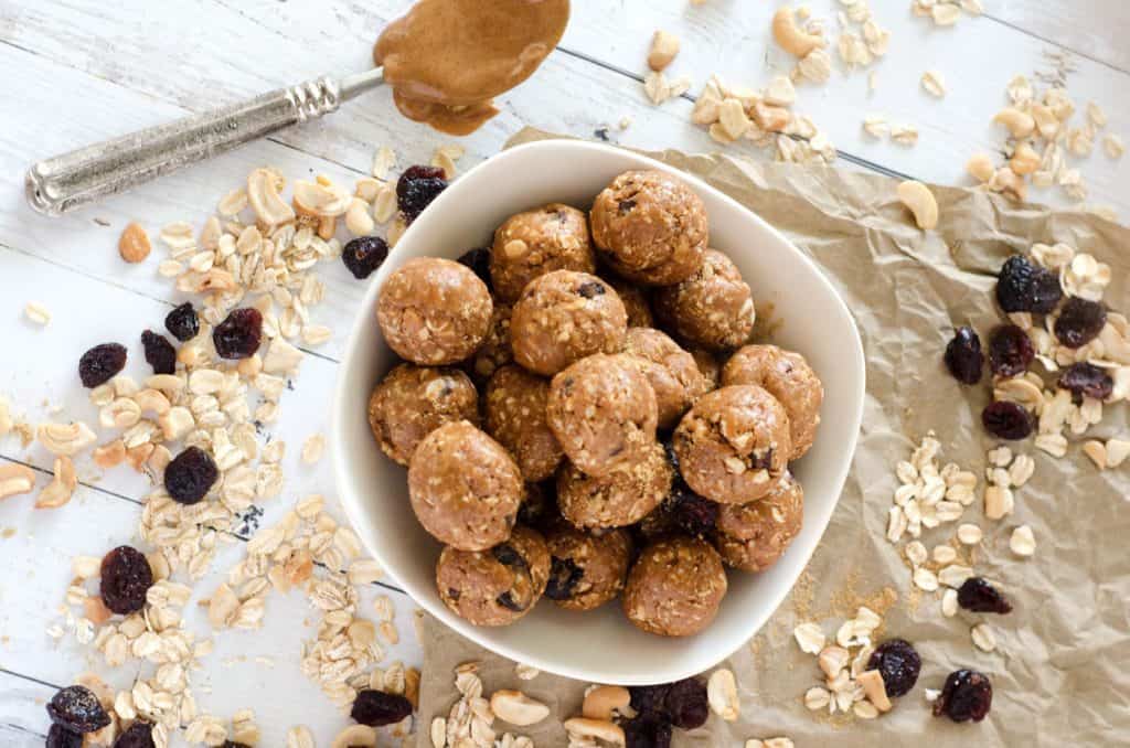 overhead view of cashew cranberry gluten free energy balls in white bowl 