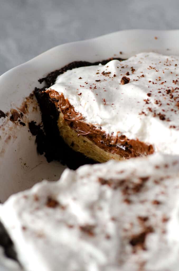 chocolate peanut butter pie in a pie pan cut to show side view of layers