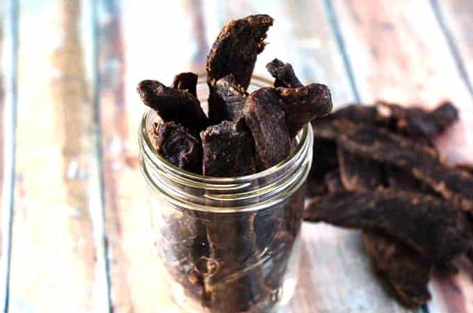 homemade paleo beef jerky in a mason jar on a wooden table