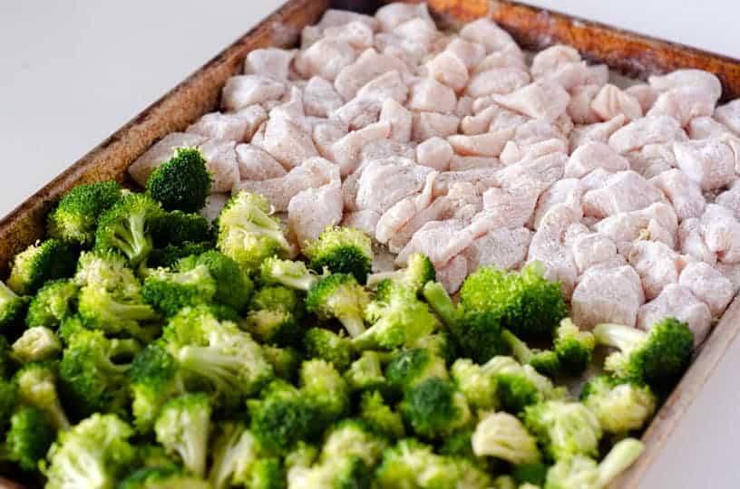 sheet pan with raw broccoli and chicken